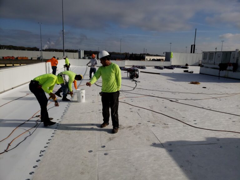 Job foremen directing crew on a commercial roof replacement